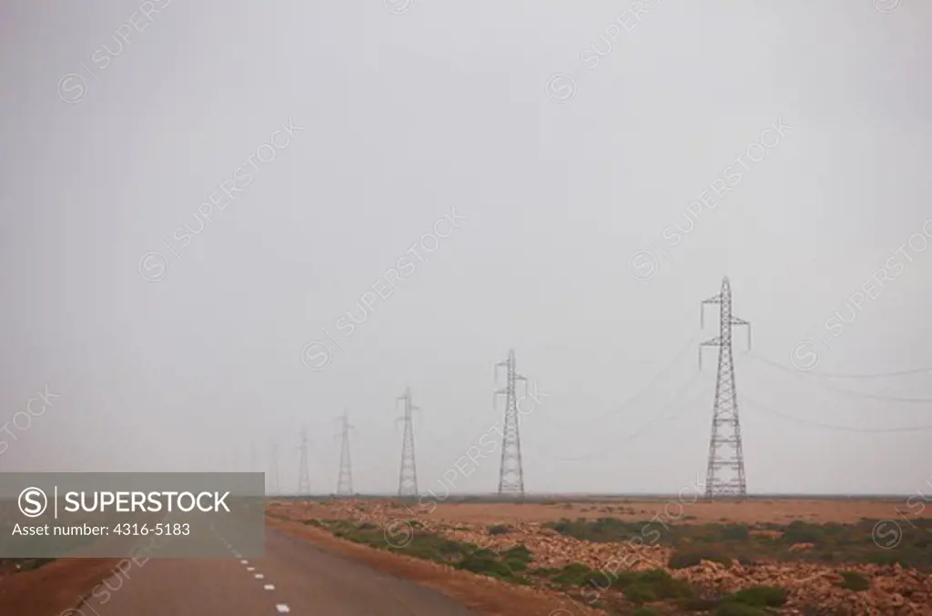 Harmattan Haze obscures view of high voltage power lines and power line towers, southwestern Morocco