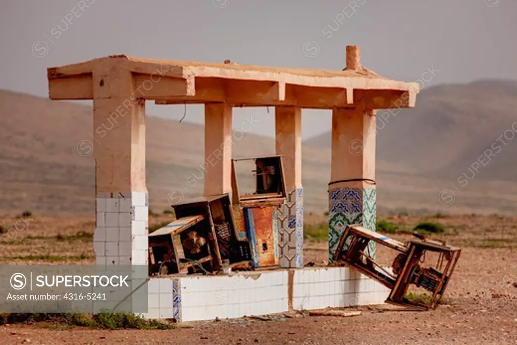 Remnants of an abandoned fuel station, rusting fuel pumps, edge of Sahara Desert, Morocco