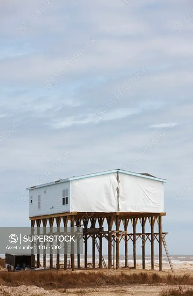 House elevated on pilings for protection from a hurricane storm surge on the Gulf of Mexico, Peveto Beach, Louisiana, USA