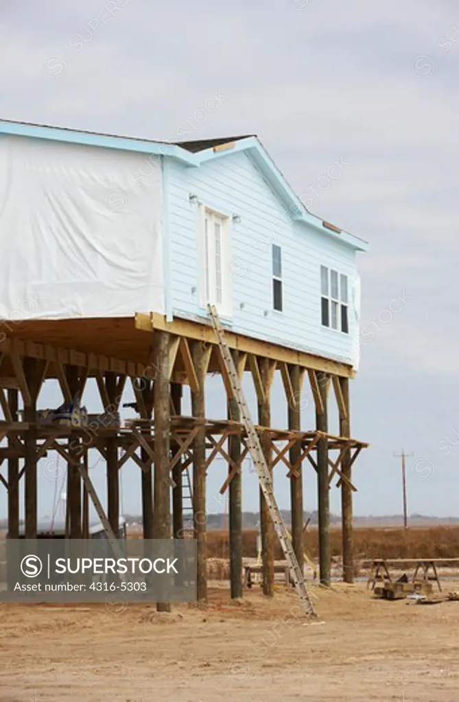 House elevated on pilings for protection from a hurricane storm surge on the Gulf of Mexico, Peveto Beach, Louisiana, USA