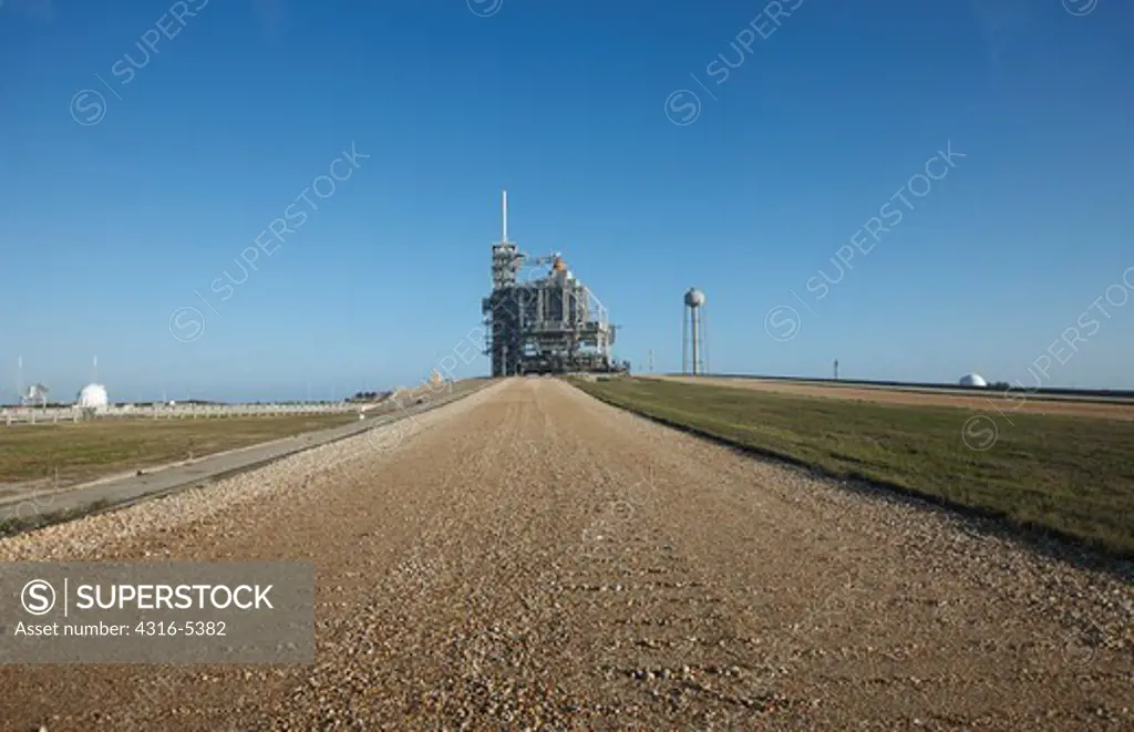 View down the Crawlerway which connects the Vehicle Assembly building with Launch Pads 39A and 39B and Launch Pad 39A with Space Shuttle Endeavour poised for launch on STS-130 lies in distance at at NASA Kennedy Space Center, Merritt Island, Florida, USA