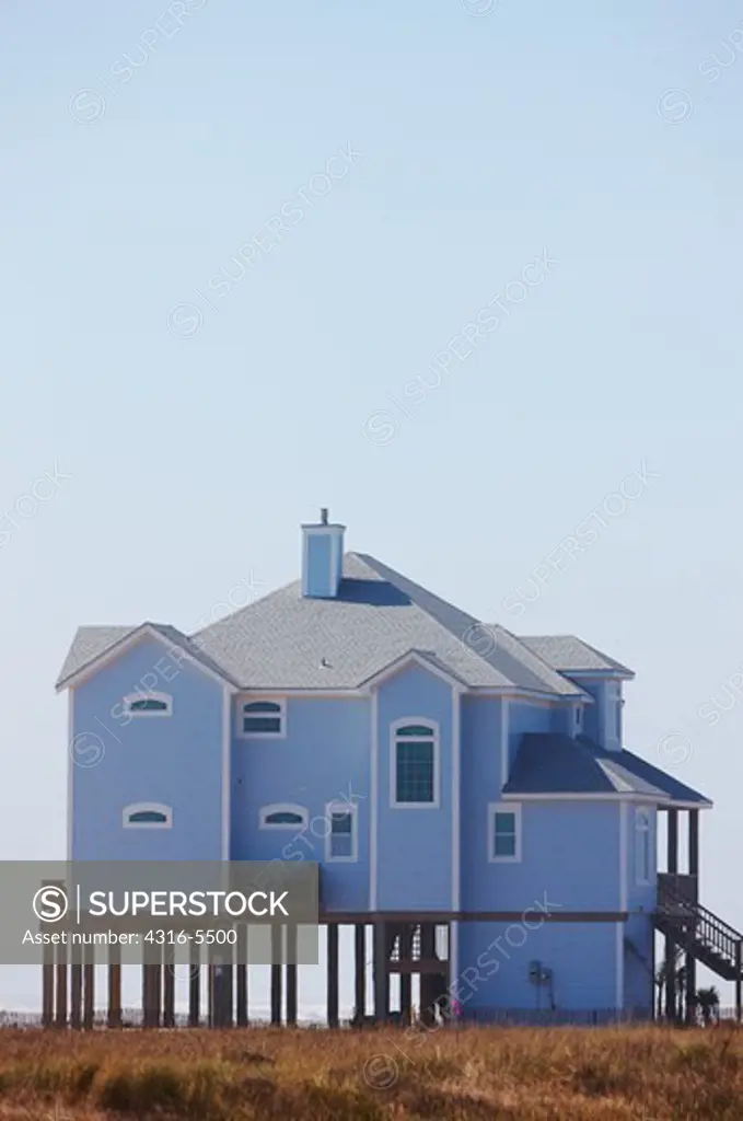 Beach house elevated on pilings for protection from a hurricane storm surge, Galveston Island, Texas, USA