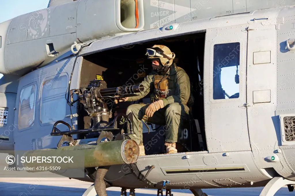 United States Marine gunner aboard a UH-1Y Venom helicopter just prior to launching on a combat operation in the Helmand Province, Afghanistan