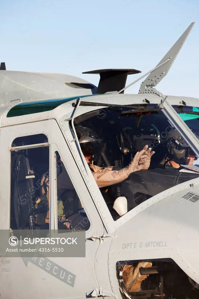 United States Marine Corps aviators raise their hands during weapons arming on their UH-1Y Venom helicopter, preparing to launch on a combat operation in the Helmand Province, Afghanistan