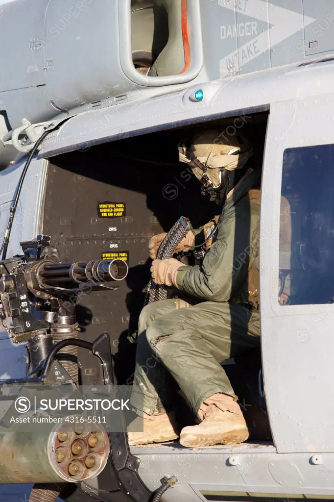 United States Marine gunner aboard a UH-1Y Venom helicopter just prior to launching on a combat operation in the Helmand Province, Afghanistan