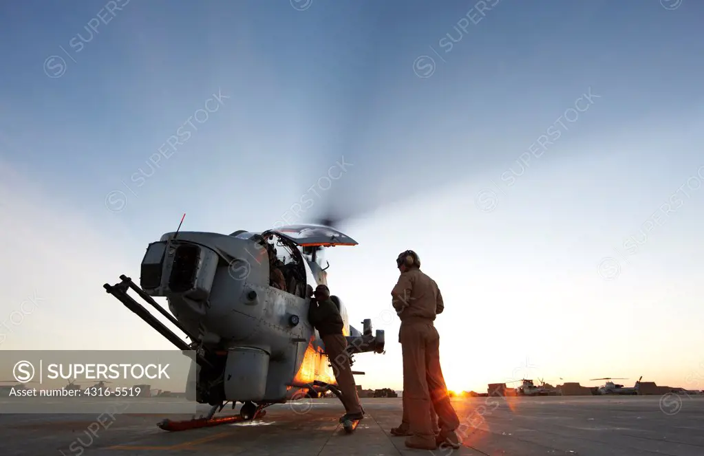 United States Marine Corps aviators and ground crew prepare to launch an AH-1W SuperCobra attack helicopter on a combat operation in the Helmand Province, Afghanistan
