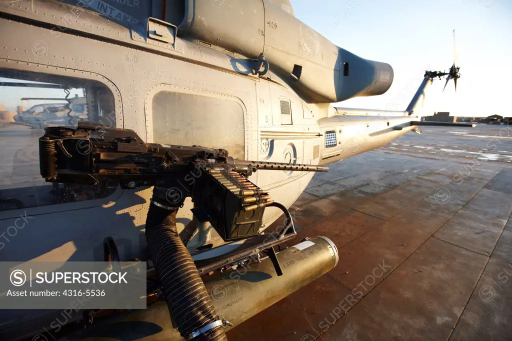 View of a 50 caliber machine gun and rocket pod mounted to the side of a United States Marine Corps UH-1Y Venom just prior to launching on a combat operation in the Helmand Province, Afghanistan from Camp Bastion