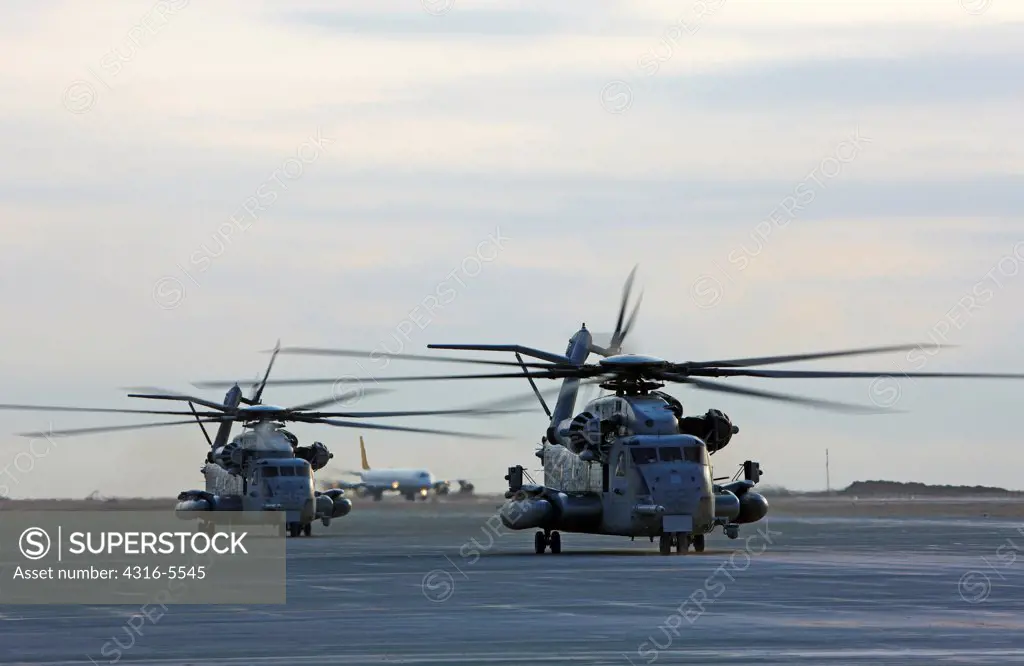 Two United States Marine Corps CH-53E Super Stallion helicopters refuel prepare to launch into the skies on a mission, Camp Bastion, Helmand Province, Afghanistan