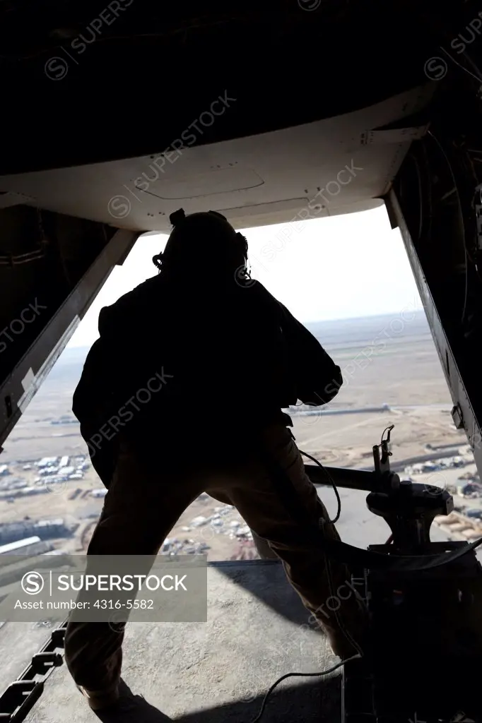United States Marine fires a .50 caliber machine out of the tail of an MV-22 Osprey during a combat operation in Helmand Province, Afghanistan