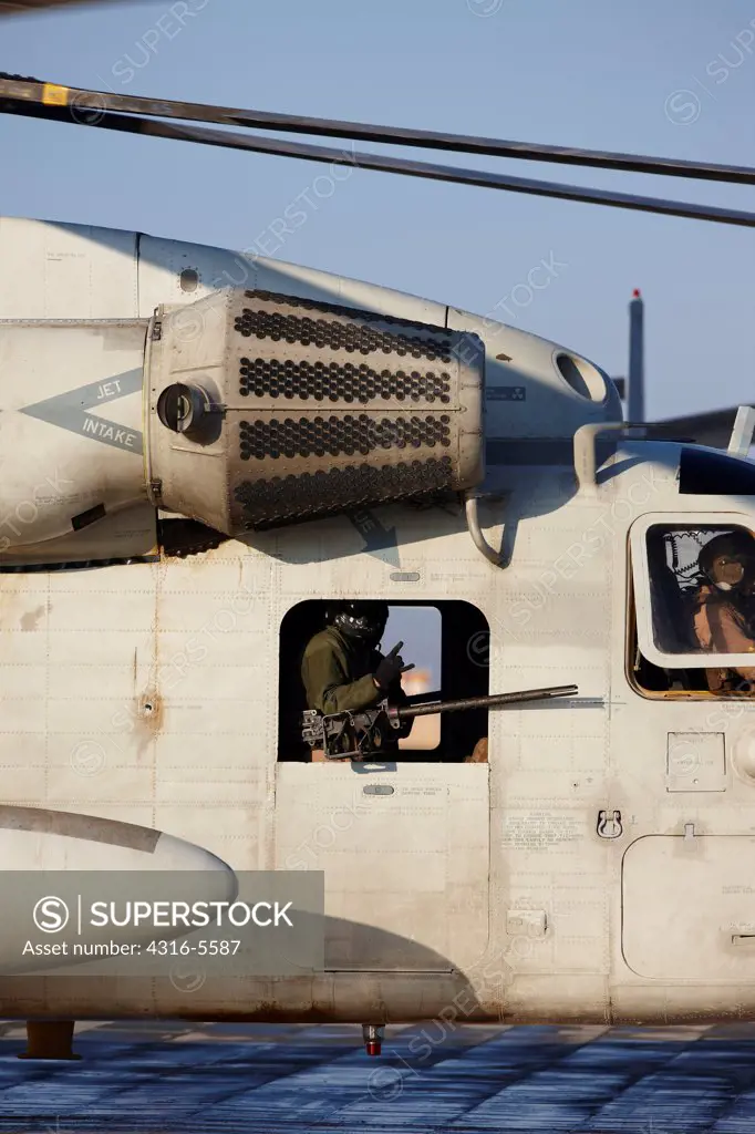 United States Marine Corps CH-53D Sea Stallion heavy lift helicopter showing window gunner and .50 caliber machine gun, Camp Bastion, Helmand Province, Afghanistan