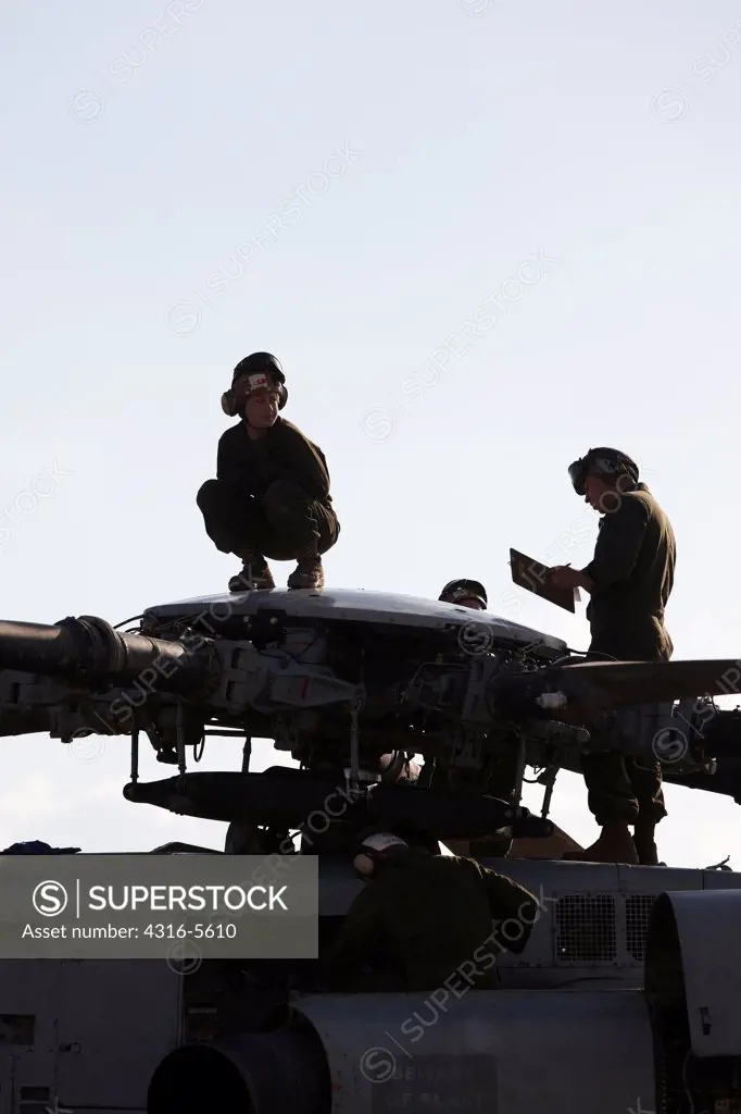 United States Marine Corps aircraft maintenance specialists working on the rotor assembly hub of a Sikorsky CH-53E Super Stallion heavy lift transport helicopter, Helmand Province, Afghanistan