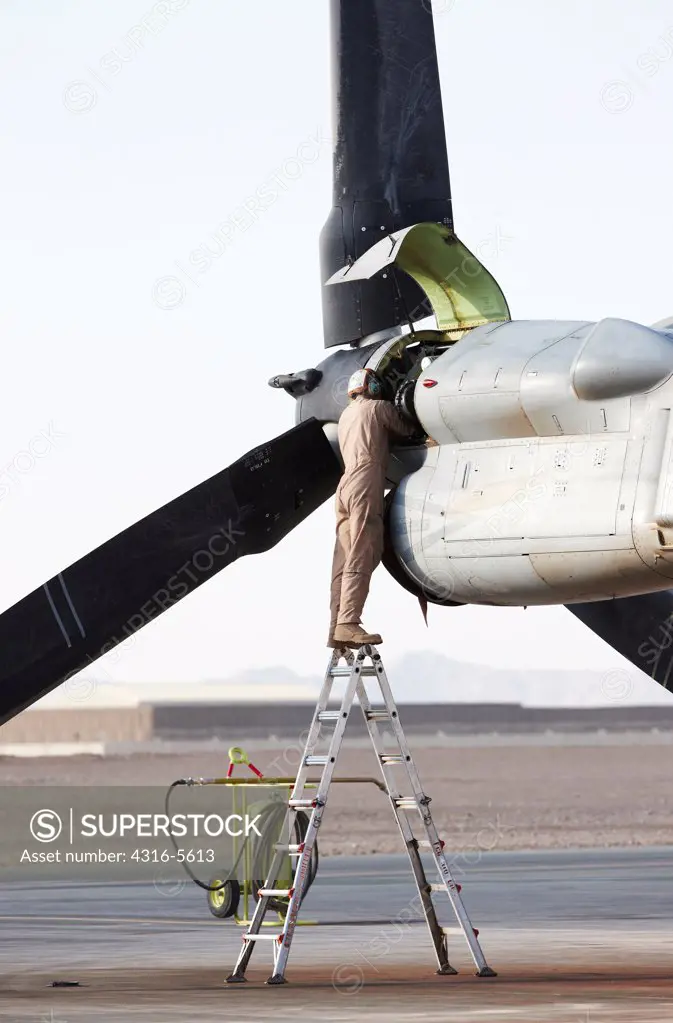 United States Marine Corps aircraft maintenance specialist working on an engine housed inside an engine nacelle of an MV-22 Osprey, Camp Bastion, Helmand Province, Afghanistan