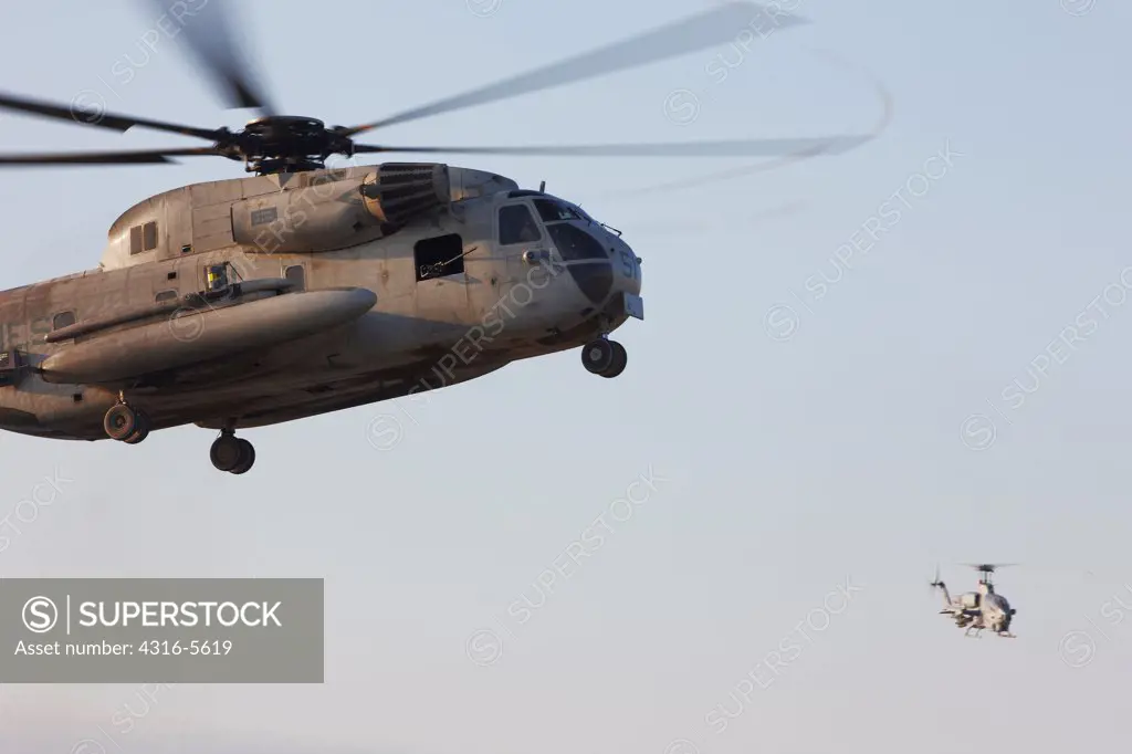 United States Marine Corps CH-53D Sea Stallion heavy lift helicopter in flight (in foreground), and a United States Marine Corps AH-1W SuperCobra attack helicopter (in background), Helmand Province, Afghanistan
