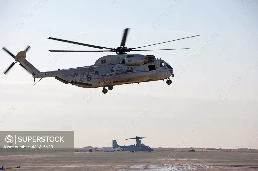 United States Marine Corps CH-53D Sea Stallion prepares to land with a United States Marine Corps MV-22 Osprey in the background at Camp Bastion, Helmand Province, Afghanistan