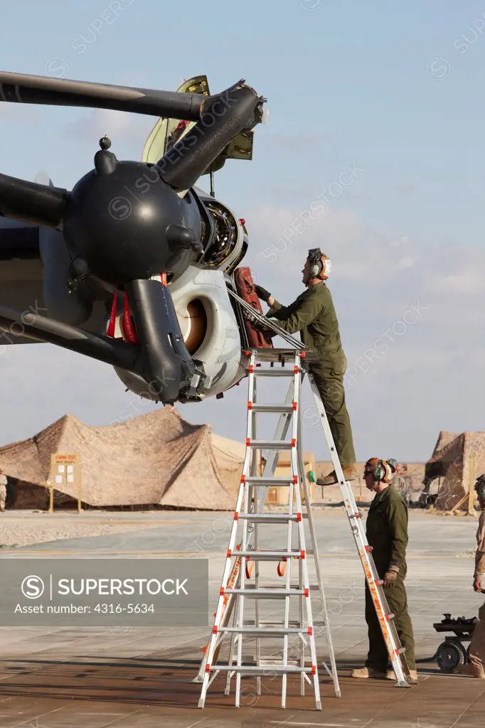United States Marine Corps aircraft maintenance specialists working on an engine housed inside an engine nacelle of an MV-22 Osprey, Camp Bastion, Helmand Province, Afghanistan