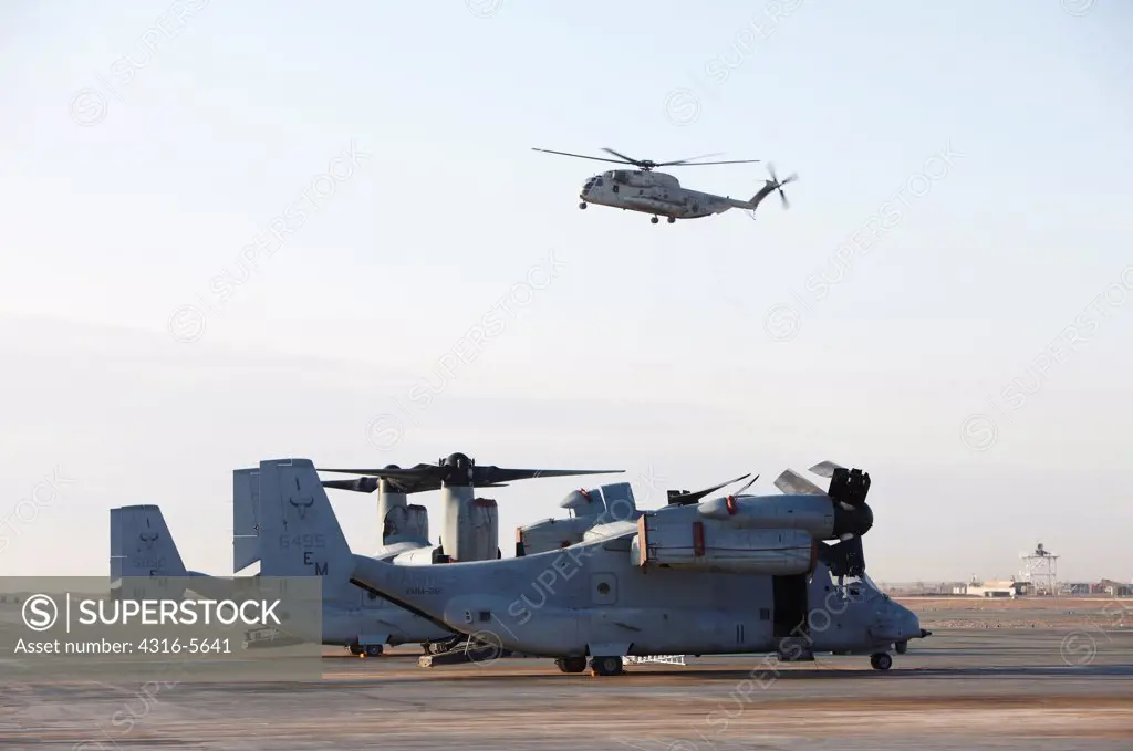 United States Marine Corps CH-53D Sea Stallion prepares to land with a United States Marine Corps MV-22 Osprey in the foreground at Camp Bastion, Helmand Province, Afghanistan