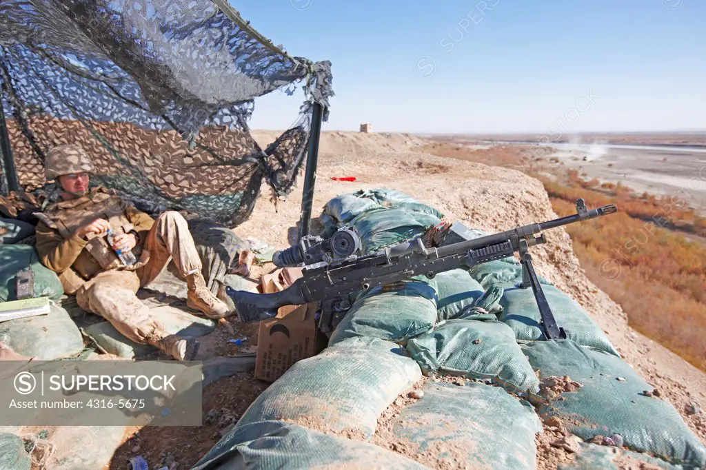 United States Marine in machine gun bunker with M240B medium machine gun overlooking the Helmand River, Helmand Province, Afghanistan