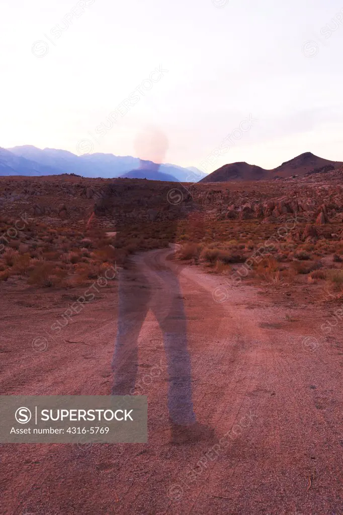 USA, California, Alabama Hills, Transparent, ghost like figure standing in dirt road, near Lone Pine