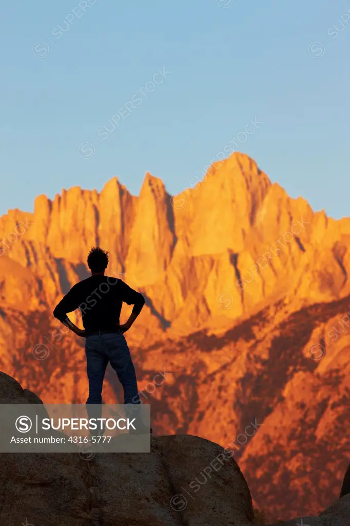 USA, California, Man gazing at Mount Whitney from Alabama Hills at dawn light