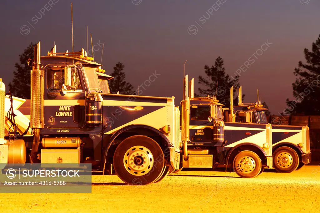 Big-Rig tractors standing in row at night