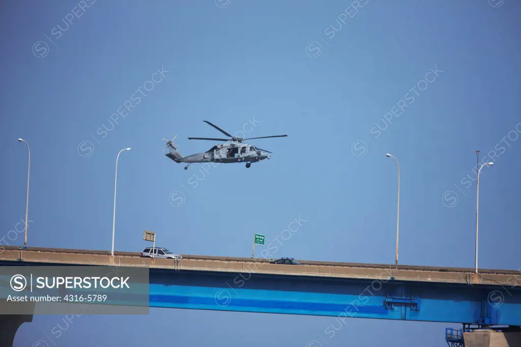 USA, California, San Diego, United States Navy Sikorsky SH-60 Seahawk flying above Coronado Bay Bridge near Port of San Diego