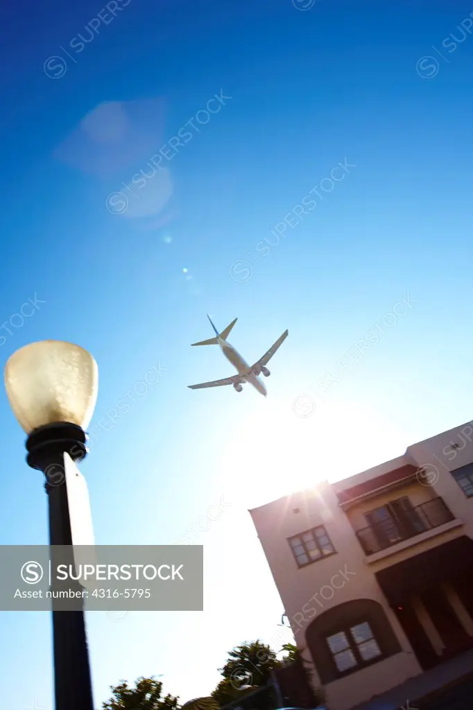 USA, California, San Diego, Jet airliner flying low over apartment complex