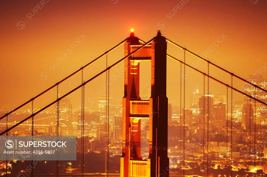 USA, California, San Francisco, Night view of north tower of Golden Gate Bridge and buildings of San Francisco