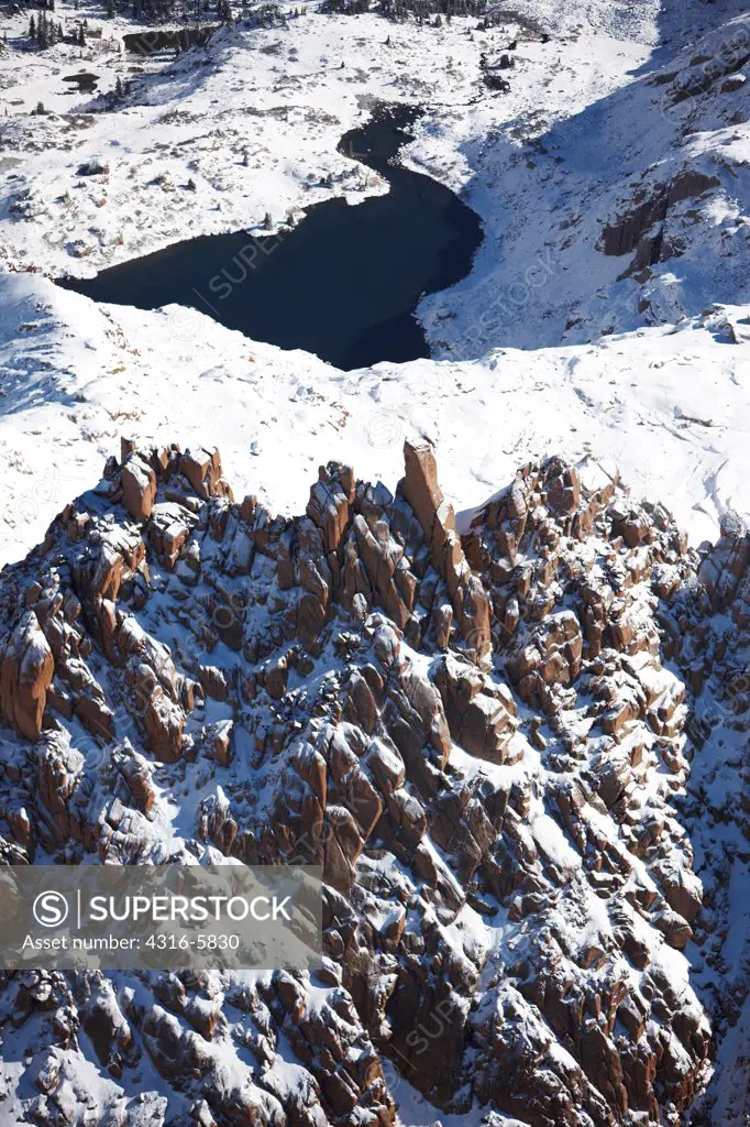 USA, Colorado, San Juan Mountains, Aerial view of fresh snowfall covering geologic forms, distant mountain lake in Weminuche Wilderness