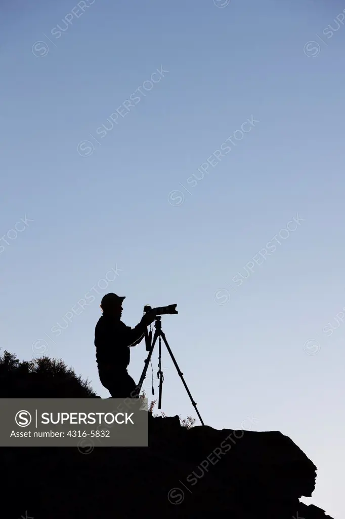 USA, Colorado, Silhouette of photographer at dawn in Rocky Mountains