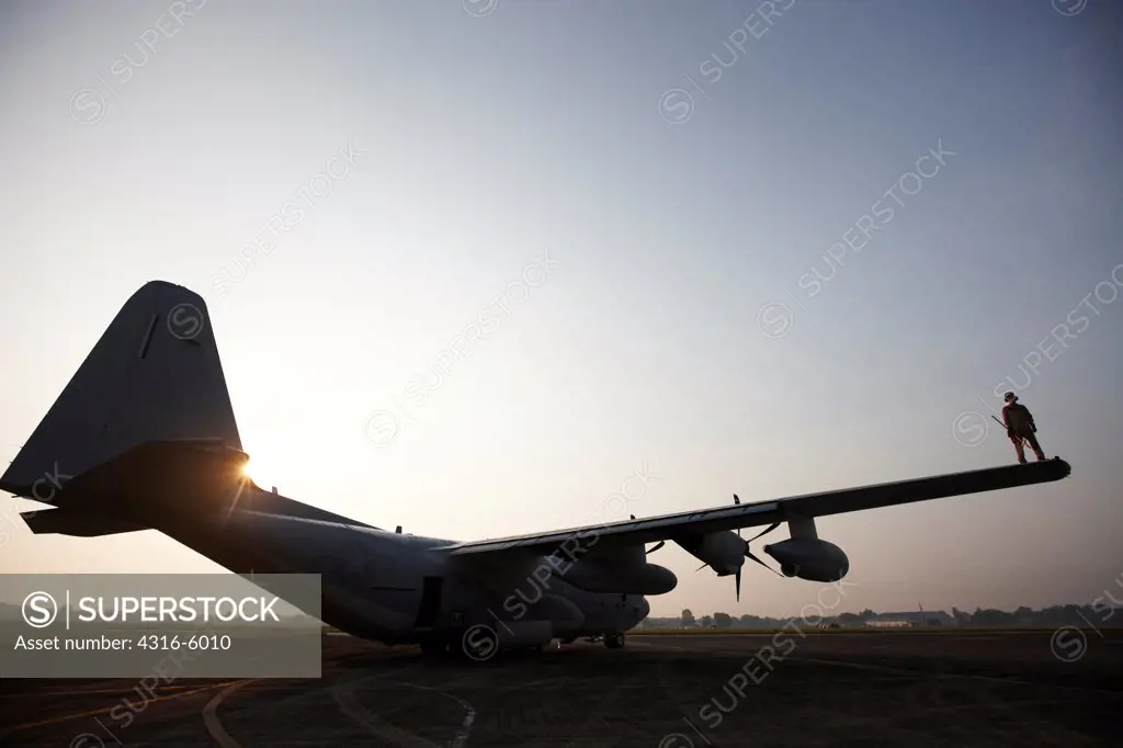 Malaysia, Kuantan Air Base, United States Marine aviation maintenance specialist inspecting wing of Marine Corps KC-130J Super Hercules