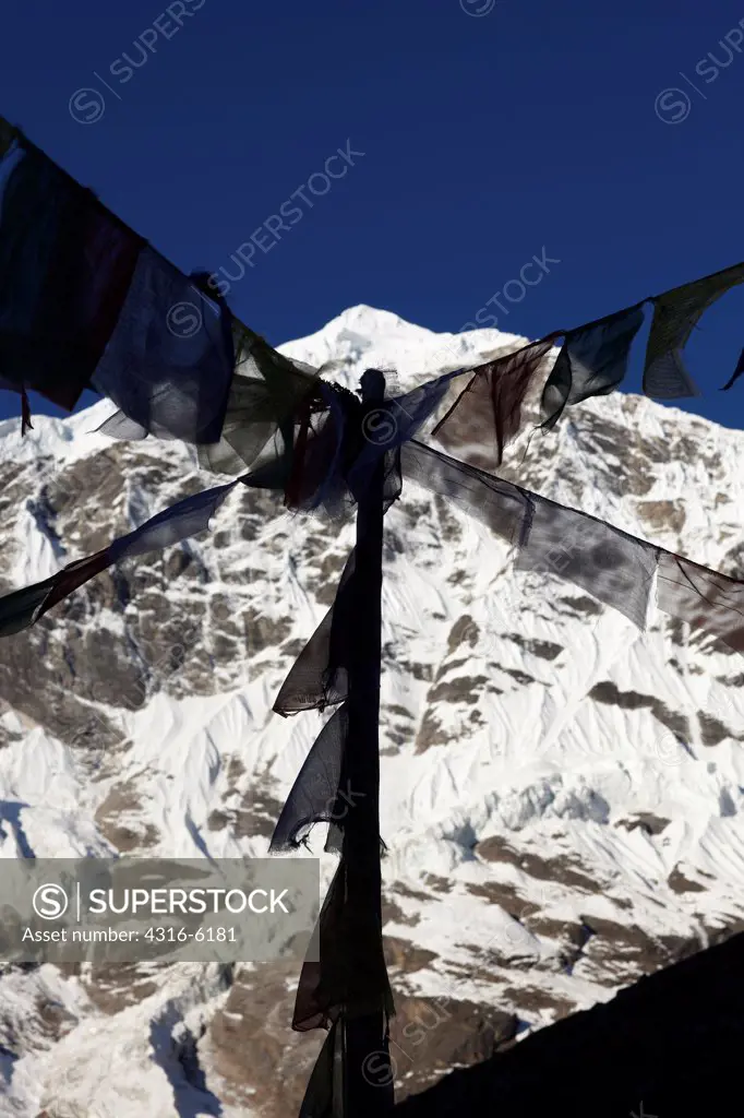 Nepal, Makalu-Barun National Park, Tibetan Buddhist Prayer flags with distant Himalayan peak