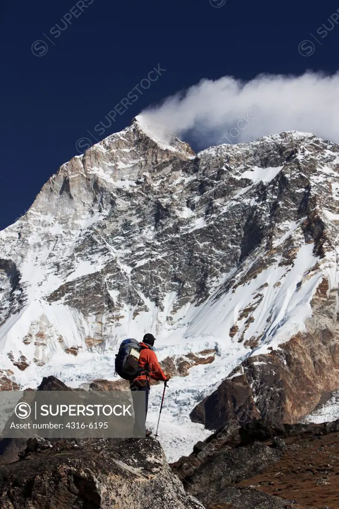 Nepal, Makalu-Barun National Park, Trekker below massive West Face of Makalu, fifth highest mountain in world at 8,481 meters above sea level