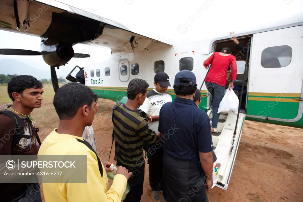 Nepal, Tumlingtar, passengers boarding into twin-turboprop aircraft at rural airstrip