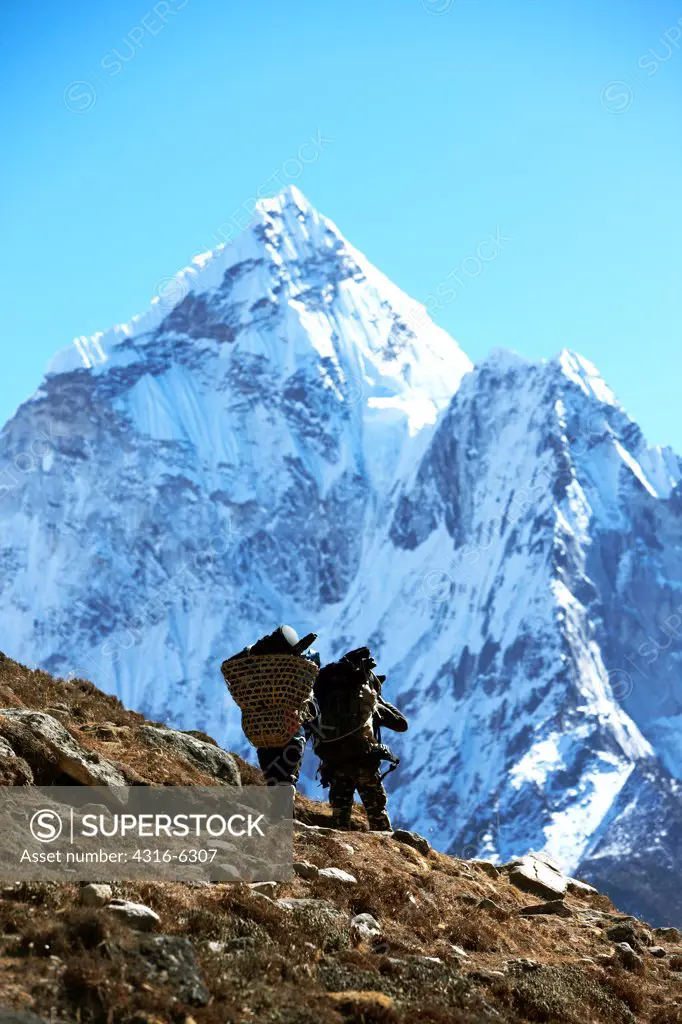 Nepal, Himalaya, Solukhumbu District, Khumbu, Sherpa porters beneath Ama Dablam, rear view