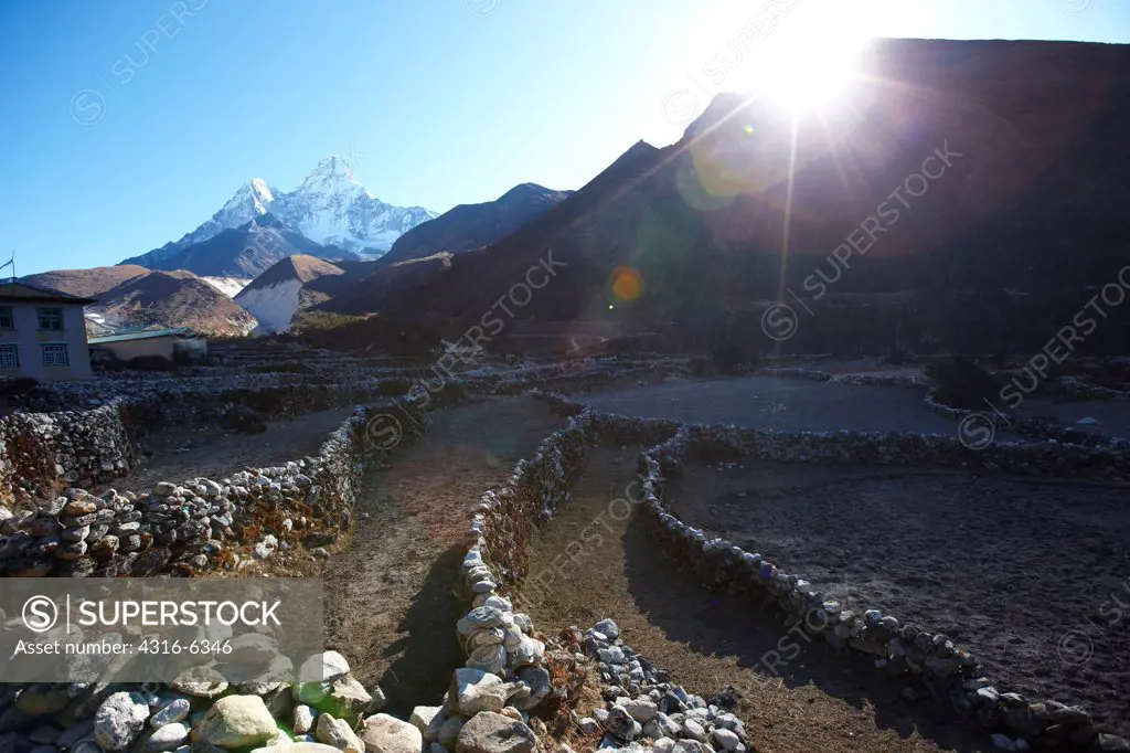 Nepal, Himalaya, Solukhumbu District, Khumbu, stone walls below Ama Dablam, solar flare