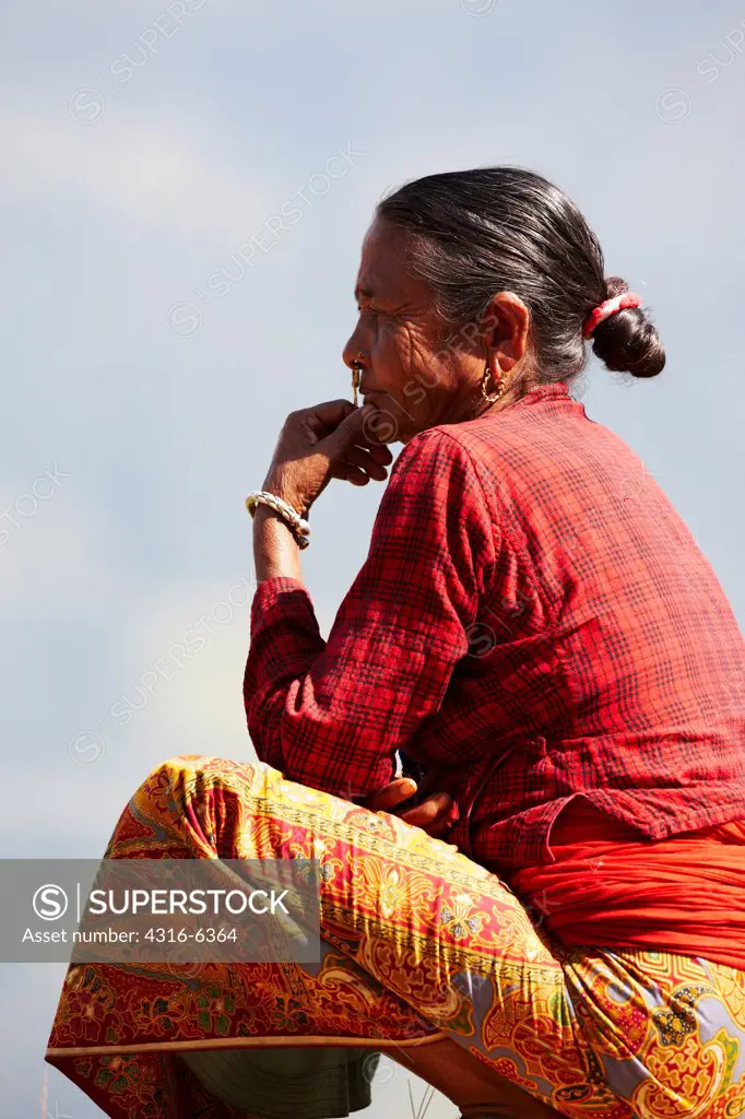 Nepal, Himalaya, Side view of elderly Nepalese woman contemplating
