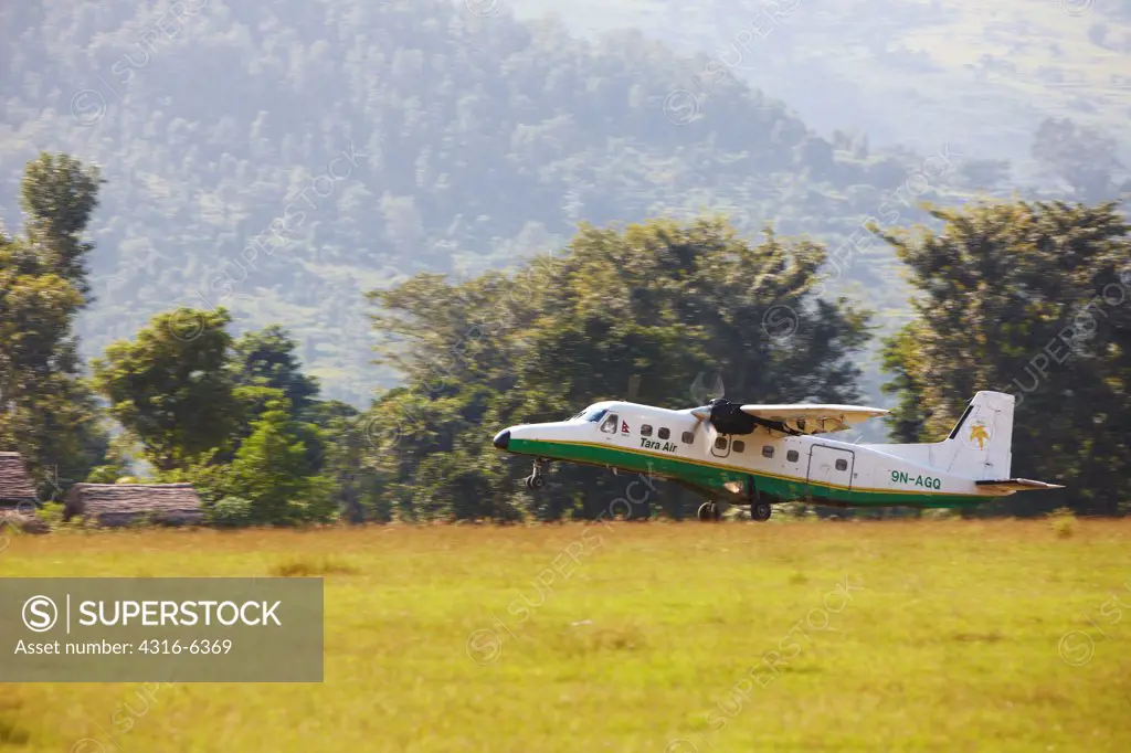Nepal, Himalaya, Tumlingtar, twin-turboprop passenger aircraft taking off on dirt airstrip