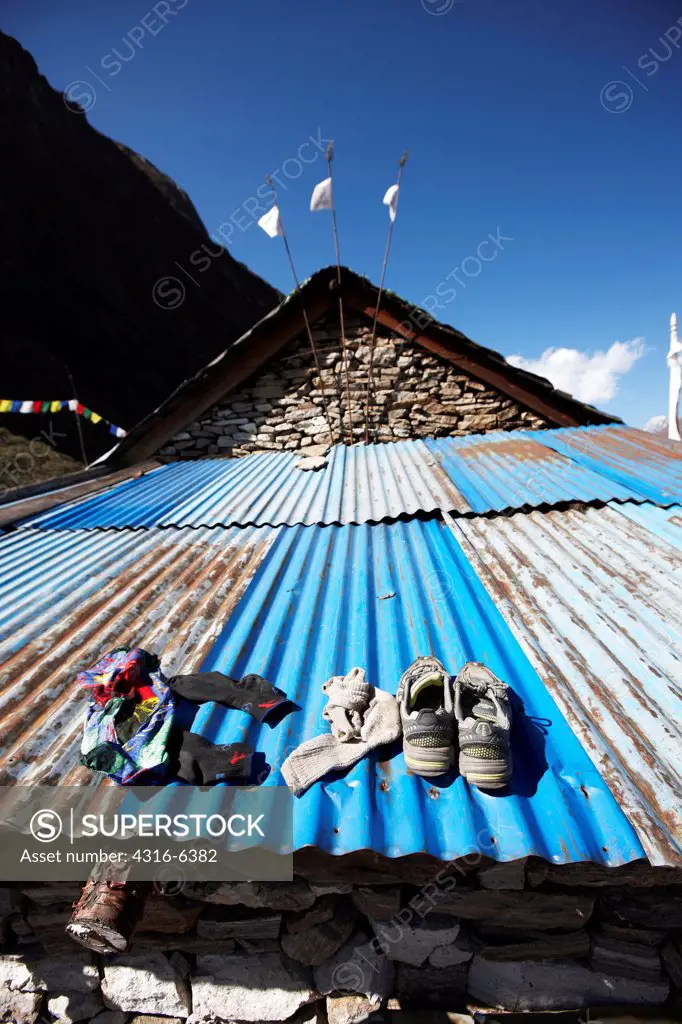 Nepal, Himalaya, shoes and socks drying on metal roof
