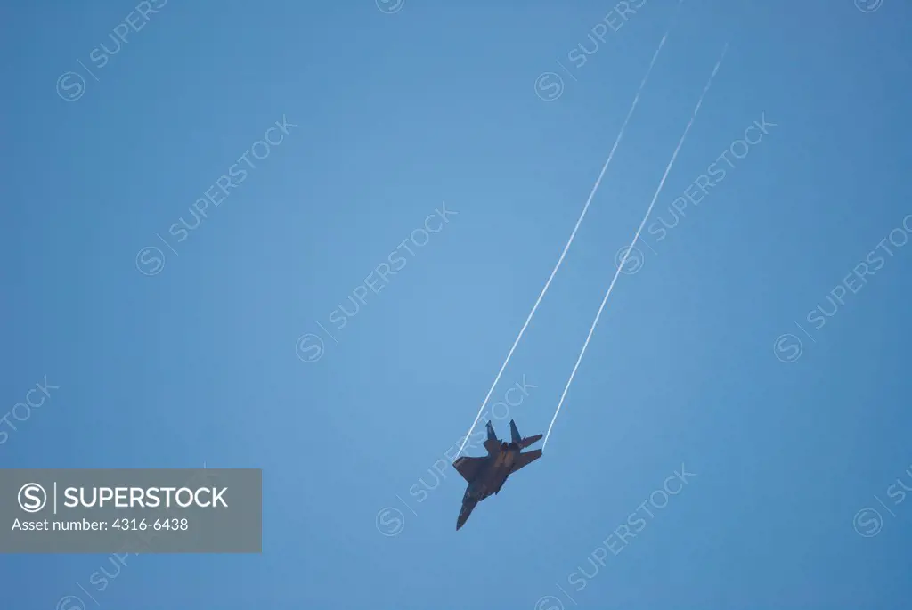 F-15E Strike Eagle in a dive with vapor trailing off the aircraft's wing tips, Mather, California, USA