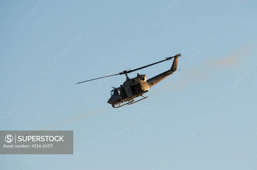 US Marine Corps UH-1N Iroquois utility helicopter fitted with machine guns and rockets firing a Hydra 70 rocket at a target at Yodaville, Barry M. Goldwater Air Force Range, Arizona, USA