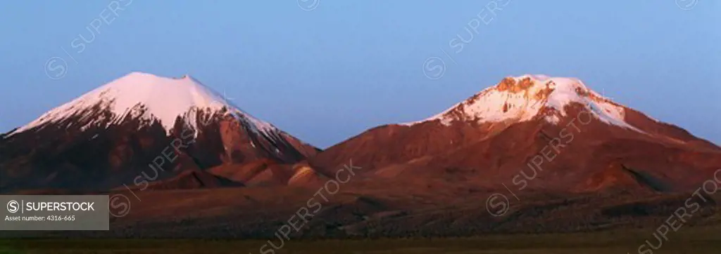The Rising Sun Casts Roseate Light On The Payachatas Volcanoes