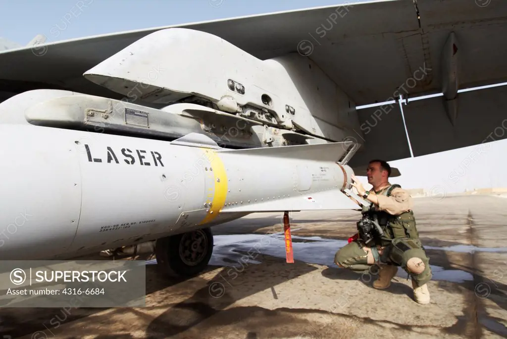 US Marine aviator inspects the tail fins of an AGM-65 Maverick missile mounted onto an F/A-18D Hornet at Al Asad Air Base, Iraq