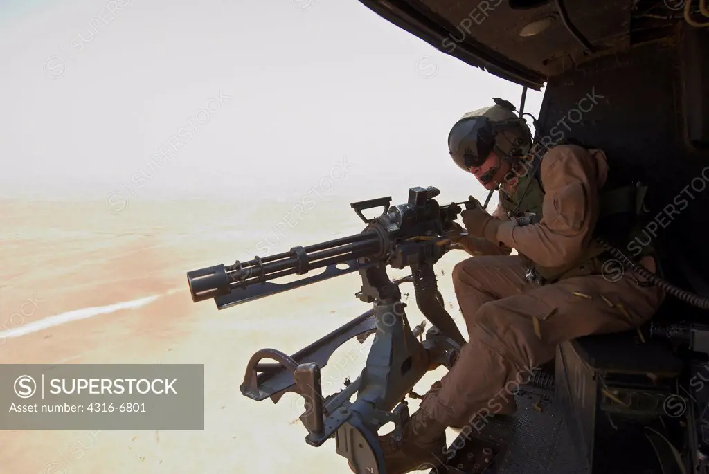 US Marine firing a GAU-17 Minigun from a Marine Corps UH-1N Iroquois helicopter at the start of a Close Air Support mission, Al Asad Airbase, Al Anbar Province, Iraq