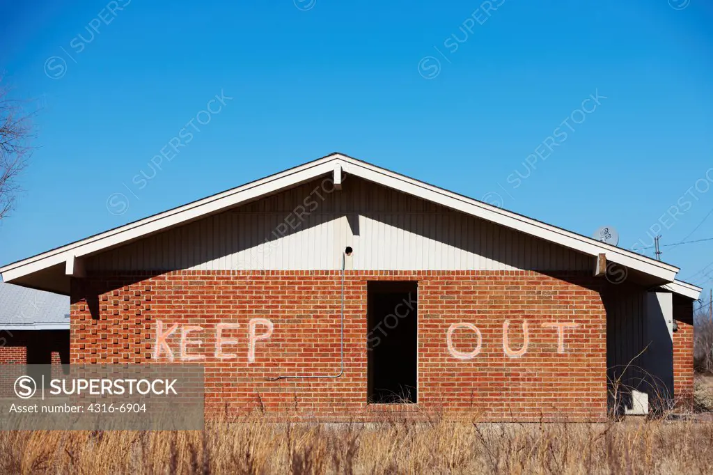 USA, Oklahoma, Picher, KEEP OUT spray painted on side of abandoned building