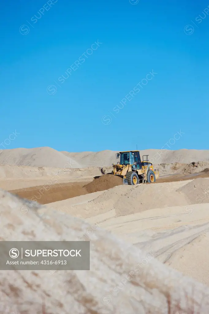 USA, Oklahoma, Picher, Front end loader moves chat, the toxic by-product of underground lead mining