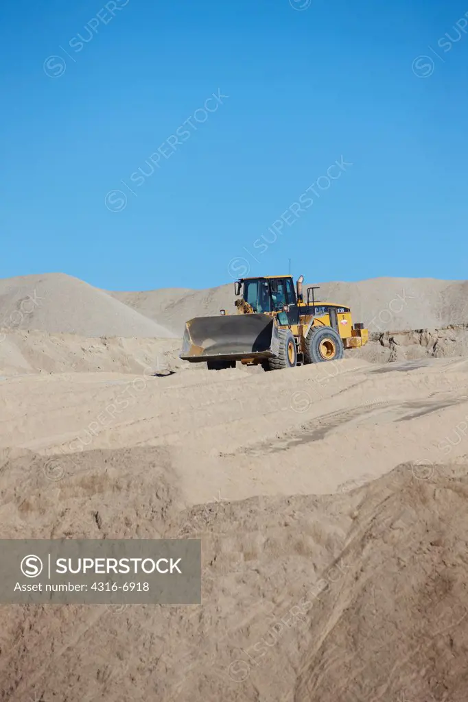 USA, Oklahoma, Picher, Front end loader moves chat, the toxic by-product of underground lead mining