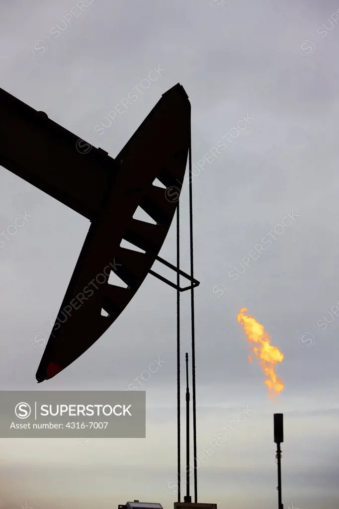 USA, Colorado, Oil well pumpjack and flaring tower