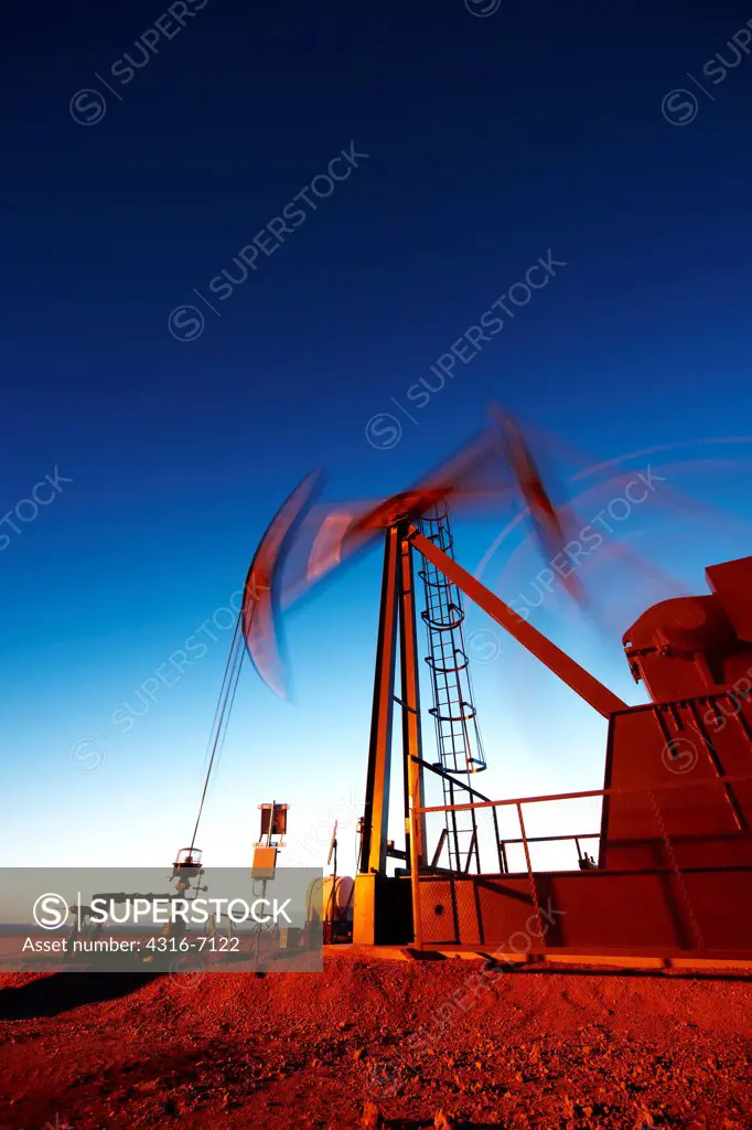 Oil well pumpjack at dusk, eastern plains of Colorado, USA