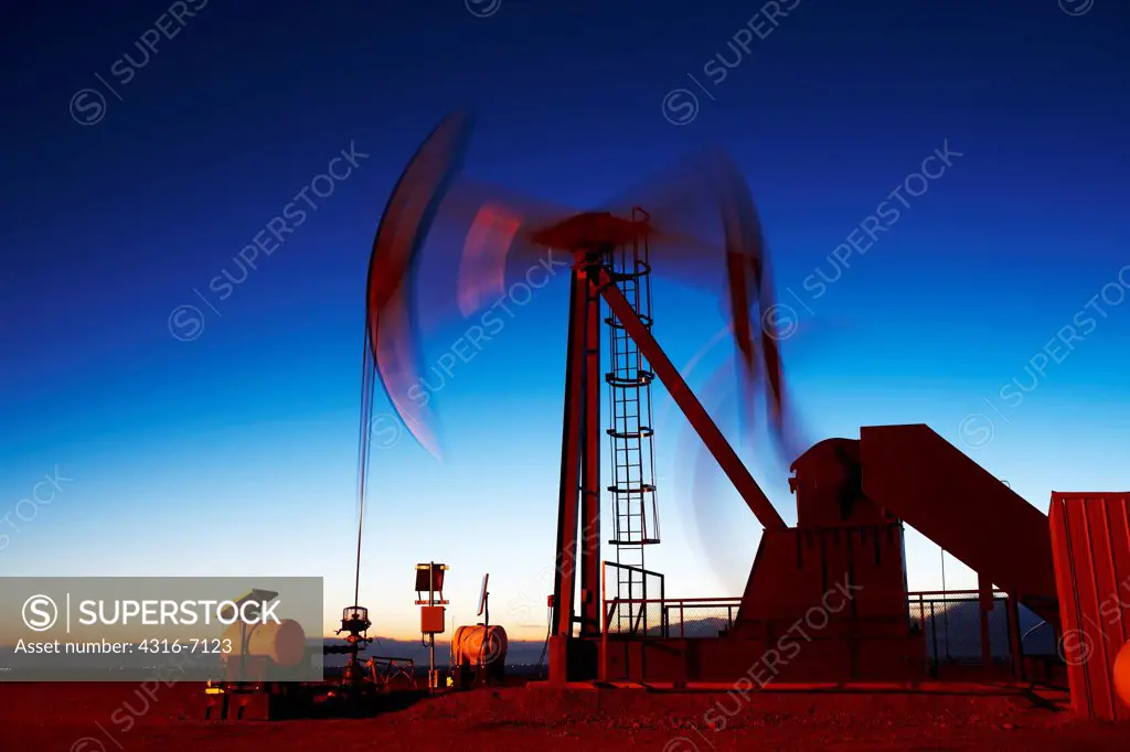 Oil well pumpjack at dusk, eastern plains of Colorado, USA
