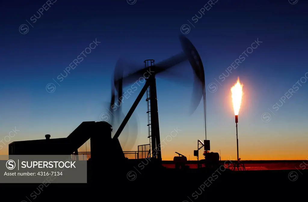 USA, Colorado, Oil well pumpjack (pump jack) and gas flare (flare stack), Oil well developed with hydraulic fracturing, also known as hydrofracking or fracking